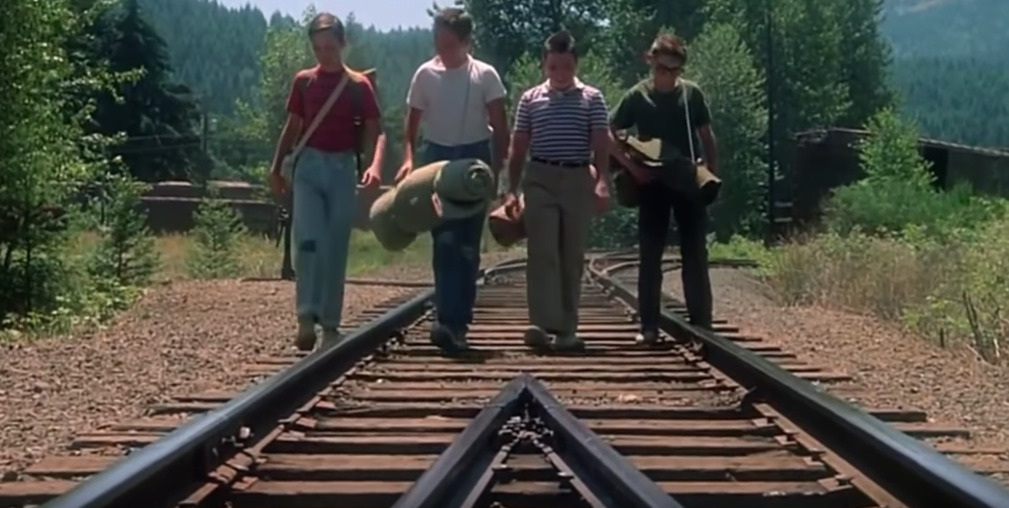 Four friends travelling on train tracks