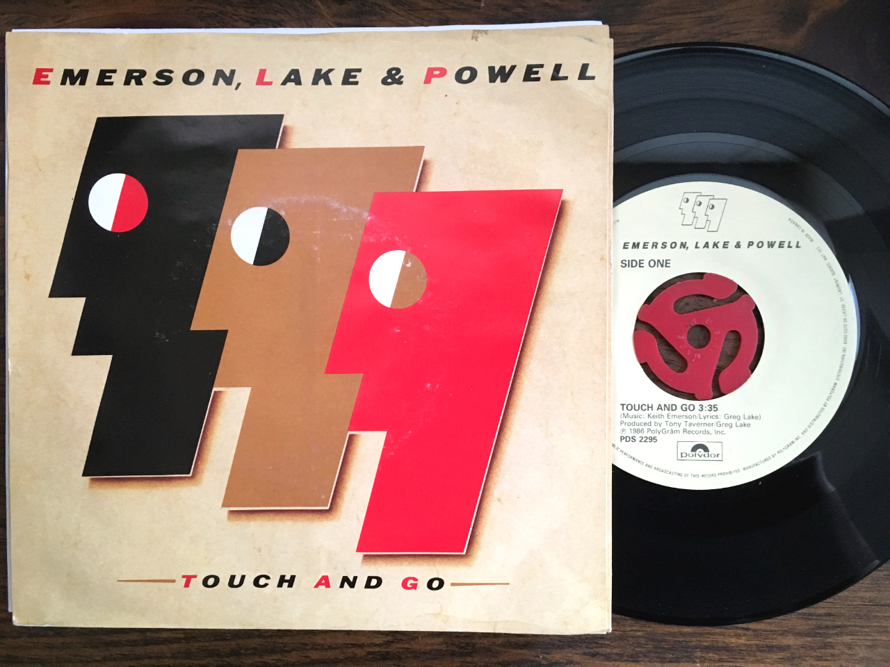 The Emerson Lake Powell Touch And Go 45 slightly out of its picture sleeve on a wooden surface.