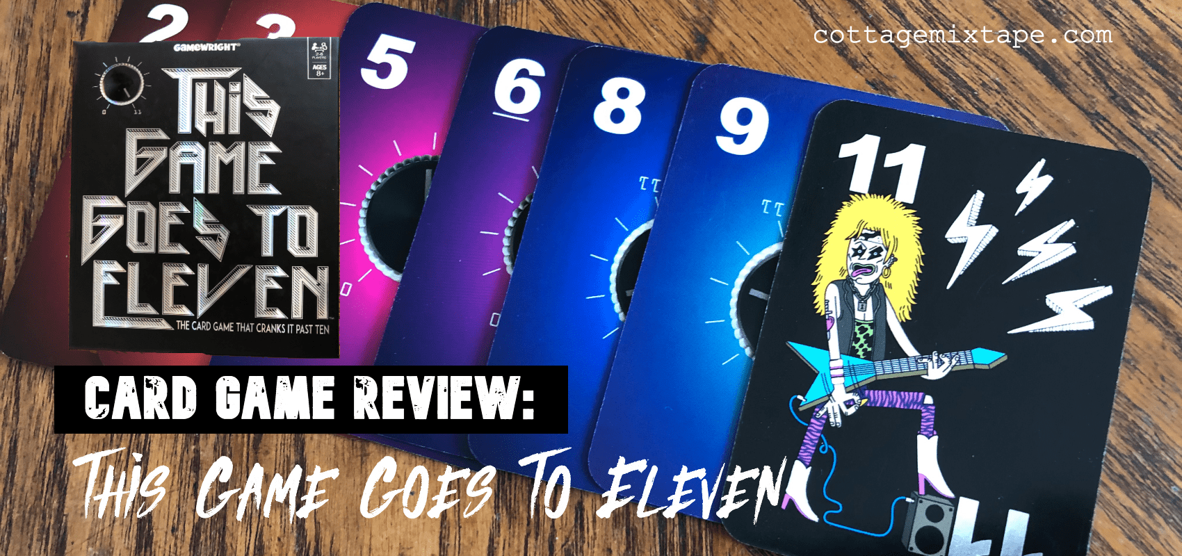 This Game Goes To Eleven cards fanned out on wooden surface.