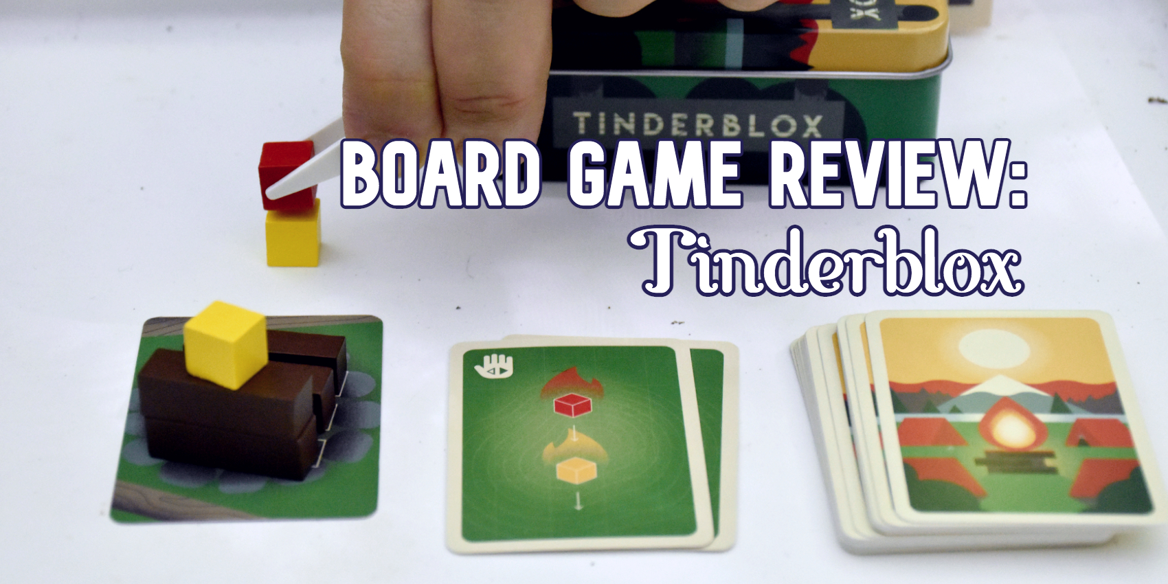 A hand with tweezers places a red cube on a yellow cube as dictated by a card.